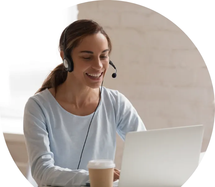 Une femme souriante avec un casque travaillant sur un ordinateur portable